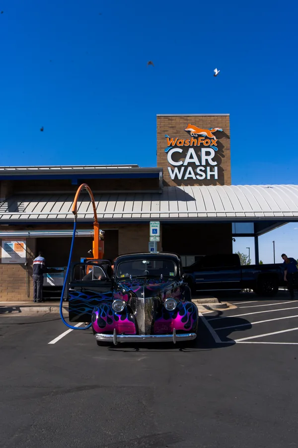 Classic hot rod parked under the Wash Fox Car Wash sign